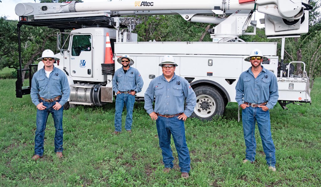 PEC linemen standing in front of bucket truck