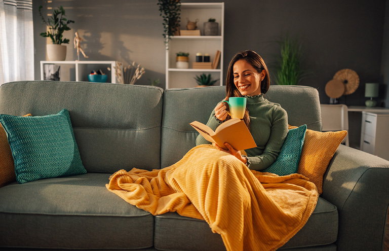 A woman reading on the couch during winter.