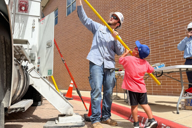 PEC lineworker with student using pole
