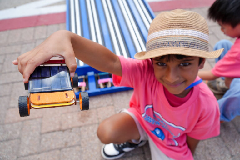 Photo of student holding up solar derby car