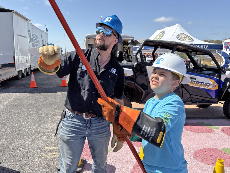 PEC employee and young person working with lineworker tools.