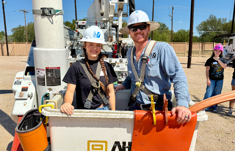 Photo of female student and PEC lineworker in bucket truck.
