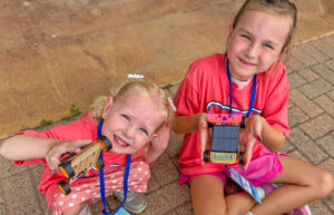 Photo of two girls showing their solar derby cars