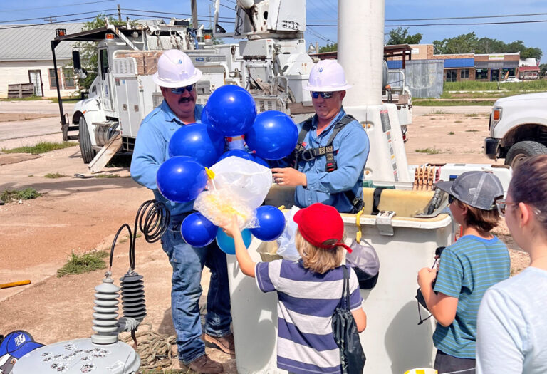 Photo of PEC linemen in bucket truck picking up eggs and balloons